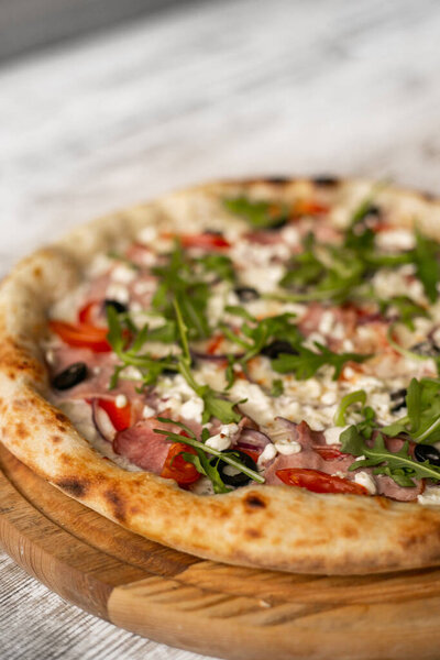 вкусная пицца с сыром и ветчиной на деревянном столе. Крупный план