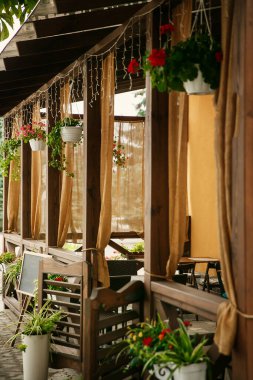 Önünde masa ve bahçe bitkileri satan sandalyeler olan kahveciler. İtalyan tarzı.
