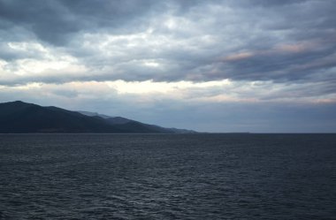 Yunan adası Thassos 'ta denizin üzerindeki renkli bulutlar