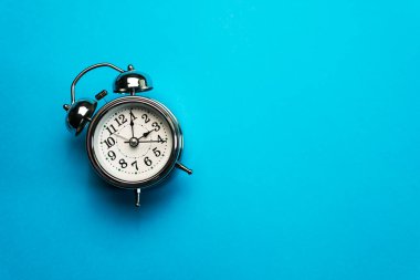 Mavi arkaplanda izole edilmiş Retro krom alarm saati.