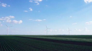 Bir yaz gününde rüzgar türbinleri ve tarım arazileri. Temiz ve yenilenebilir enerjili enerji üretimi.