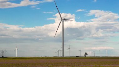Bir yaz gününde rüzgar türbinleri ve tarım arazileri. Temiz ve yenilenebilir enerjili enerji üretimi.