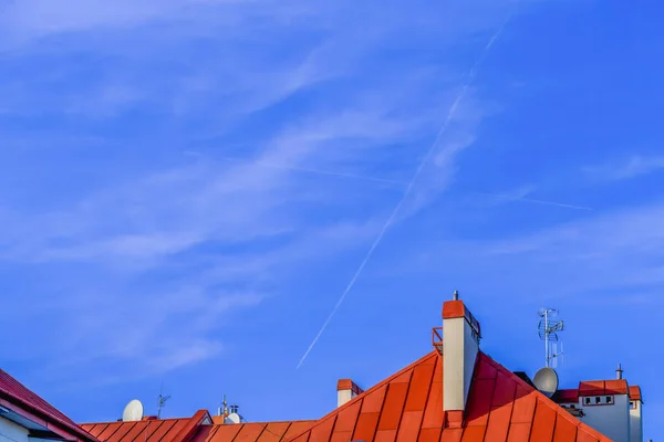Två Korsade Spår Flygplan Den Blå Himlen Över Röda Taken — Stockfoto