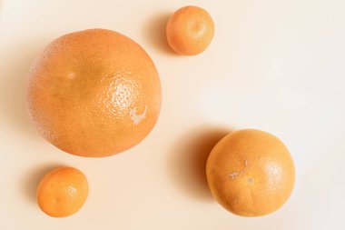 Sıcak kum gradyanı üzerine soyut minimalist desenli greyfurt, portakal ve mandalina, narenciye meyvelerinin yumuşak gölgeleri, meyveler ve sağlıklı beslenme üzerine güzel doğal arka plan fotoğrafçılığı, düzlük