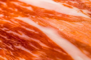 Arka plan ve ekran koruyucu için iberico jamon (serrano jamon) dilimlerinin soyut deseni, İspanyol jamonun et dilimlerinin arka planı, ince et dilimlerinin dokusu. Seçici odak, düz kenar