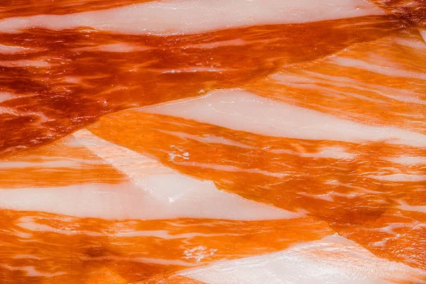 Ekran koruyucu ve arka plan için Iberico jamon 'un (serrano jamonu) soyut desenleri, İspanyol jamonunun sulu et dilimlerinin yakın çekimi, ince et dilimlerinin dokusunun makro fotoğrafı