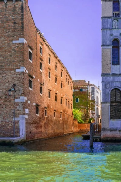 阳光明媚的日子里 威尼斯一条狭窄的运河街上的古老房屋的砖墙 威尼斯城市运河威尼斯房屋的蓝天 在意大利旅游 纵向定向 — 图库照片