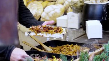 Bir şef, Polonya 'nın Krakow kentindeki bir Noel pazarında açık hava sokak kafesinde büyük bir sıcak ekmek sandviçi yapar. Noel ve Yeni Yıl arifesinde Polonya aşçılık geleneklerinin özgün sahnesi