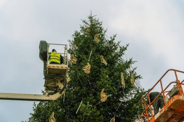 Kamu çalışanları uzun bir şehir ağacını Noel 'den önce Polonya' nın Krakow kentindeki bir sokakta Noel oyuncaklarıyla süslüyor. Polonya 'nın Noel ve Yeni Yıl kutlamalarının otantik sahnesi