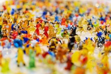 Üniformalı bir yüzeyde büyük miktarlarda renkli minyatür cam oyuncaklar. Yumuşak seçici odak, neşeli olaylar için neşeli pozitif arka plan görüntüsü. Boşluğu kopyala