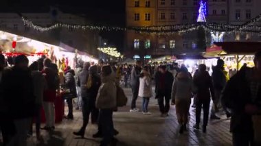 KRAKOW, POLAND - 12.05.2022: Krakow Pazar Meydanı 'nda geceleyin Noel pazarı. Polonya Yeni Yıl Oyuncak ve Hediyeleri Fuarı, Otantik Ulusal Mutfak, Çarşıda el sanatları ile tezgahlar
