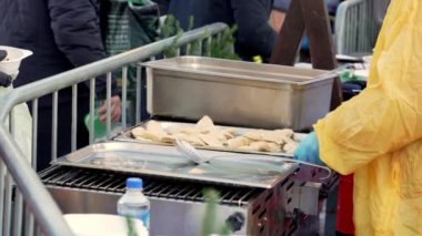 Soğuk bir kış günü Krakow sokaklarında, hayır kurumunun gönüllüleri ihtiyacı olan herkesi sıcak yemeklerle bedavaya besliyor, Noel 'den önce ihtiyacı olanlara özverili yardım geleneği.