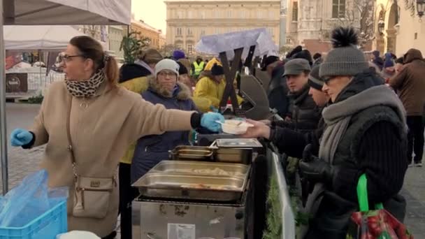 Krakow ポーランド 2022 慈善団体のボランティアが 寒い冬の日に無料の温かい食べ物を必要としているすべての人々に食べさせ クリスマス前に助けを必要としている人々に無私の伝統 — ストック動画
