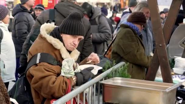 克拉科夫 2022年12月18日 在寒冷的冬日 一位老人从慈善组织志愿者那里得到了一份热腾腾的免费午餐 这是在圣诞节前无私地帮助那些需要帮助的人的传统 — 图库视频影像