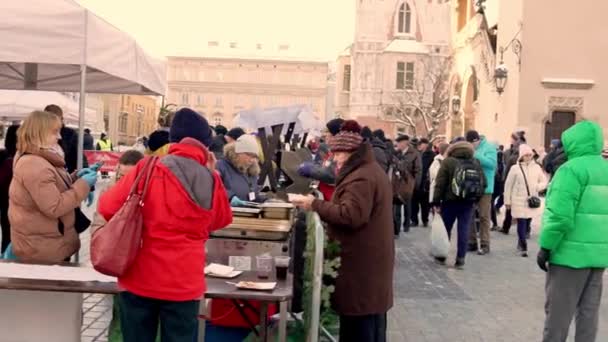 Krakow ポーランド 2022 寒い冬の日に慈善団体ボランティアから無料の温かい食事を受け取り クリスマス前に助けを必要としている人々に無私の伝統 — ストック動画