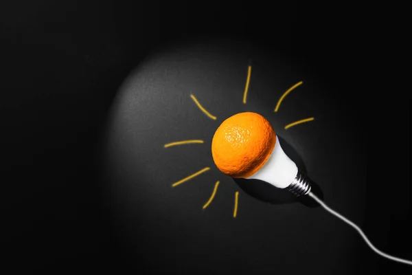 Creative concept of sustainable development of technology, renewable resources. Minimalistic concept of green energy sources. Mixed dimension, LED lamp with tangerine shade and hand-painted beams