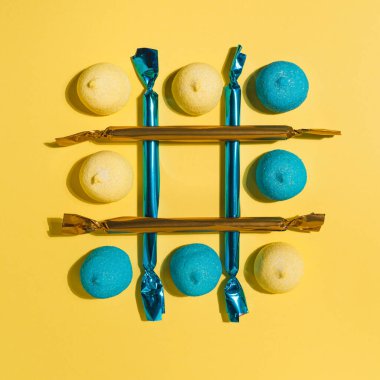 Tic-tac-toe, içinde boş bir kafes olan sarı ve mavi şekerleme deseni. Parti, piknik ve Sevgililer Günü için nefis bayram şekerleri. Kopyalama alanı olan minimalist desen, düz yatay