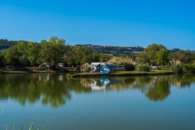 Gölün kıyısındaki motorlu evler kamp masaları, dinlenmek için balıkçılık, yaz tatili ve açık hava eğlencesi, otantik sürdürülebilirlik ve doğal doğa güzelliği.