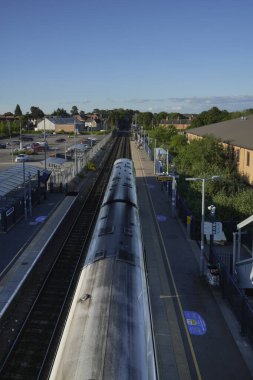 Tren İngiltere 'de bir tren istasyonunun platformunda bekliyor. Yolcular tren ve ulaşım ağını kullanarak seyahat edebilir, seyahat edebilir ve seyahatlere çıkabilirler.