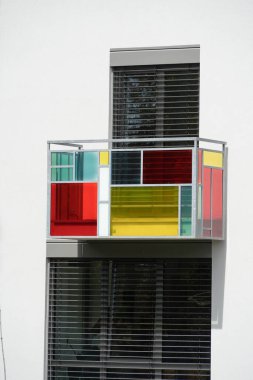Renkli cam panellerin geometrik desenlerini içeren soyut mimari detay De Stijl veya Mondrian tarzını anımsatıyor. Modern tasarım ögesi ön cephede.