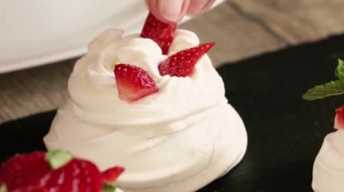 Dessert of meringue with fresh strawberries. Beautiful serving of dessert in the restaurant. Pavlova's dessert. Close-up of the dessert.