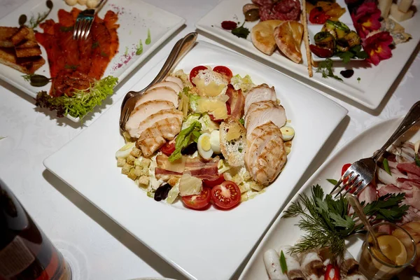 Chicken Salad. Chicken Caesar Salad. Caesar Salad with grilled chicken and croutons. Grilled chicken breast and fresh green salad. Table setting in a restaurant