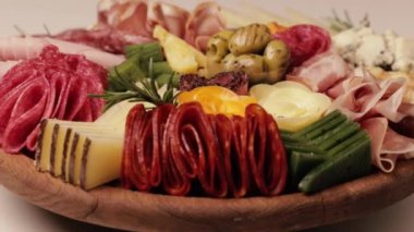 Şarküteri ve peynir tabağı kendi ekseni etrafında sorunsuzca döner. Çeşit çeşit peynirli aperatifler, salam, jambon, üzüm ve fındık. Video döngülendi