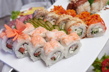 Somon, füme yılan balığı, avokado ve krem peynirli suşi rulosu. Suşi menüsü. Japon yemeği..