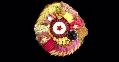 Çeşit çeşit peynirli aperatifler, salam, jambon, zeytin ve fındık. Şarküteri ve peynir tabağı. Üst Manzara. Video bir alfa kanalı, şeffaf arkaplan ile çevrilidir