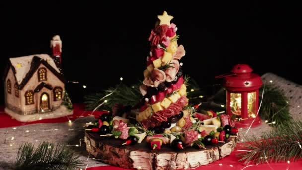 異なるアンチパスティ チャーター スナック チーズを備えたアペタイザーボード 肉のクリスマスツリー ソーセージの料理とチーズクラフトの木製ボード ブラックバックのクリスマスの装飾 — ストック動画