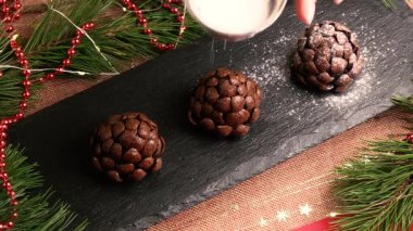 Şef, ladin ya da çam kozalağı şeklinde el yapımı çikolatalı keklere şeker serpti. Noel ve yeni yıl için güzel pişmiş yiyecekler.