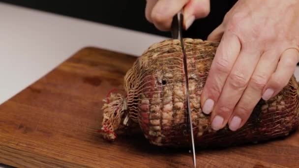 シェフはナイフで木製の板に大きな豚ハムを切った おいしいおいしいお肉クローズアップ — ストック動画