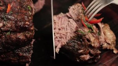 Şef büyük bir parça fırında veya kızarmış et keser ve etin ne kadar sulu ve yumuşak olduğunu gösterir. Yakın plan.