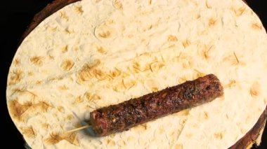 Kebap: Kıyma şiş üzerinde ızgara sosis. Şef onları birbiri ardına pide çarşafına seriyor. Üst Manzara. Doğu mutfağı.