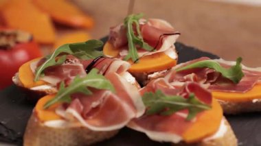 Jambonlu sandviçler, taze tost, iberico. Şef aperatifi sosla süslüyor. Yan görünüm, yakın plan