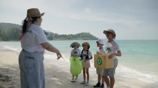 子供たちのボランティア海洋汚染を減らすためにビーチでプラスチックごみを収集しています — ストック動画