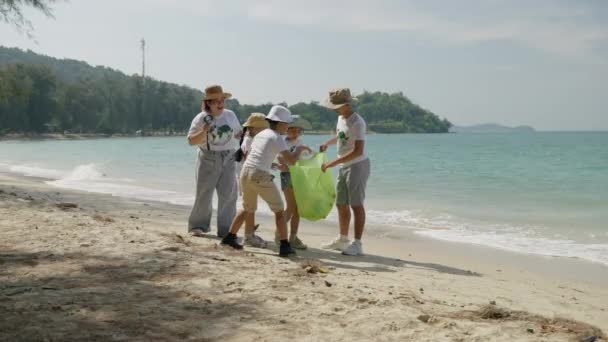어린이 봉사자들은 오염을 줄이기 해변에서 플라스틱 폐기물을 모으고 있습니다 — 비디오