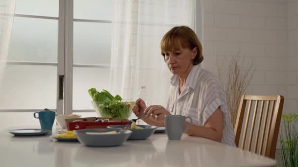 Kaukasische Ältere Frau Die Allein Hause Sitzt Und Allein Frühstückt — Stockvideo