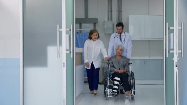 病人和坐轮椅通过医院走廊的亲属 讨论缓解焦虑的症状 医疗护理的概念 医疗保健 — 图库视频影像