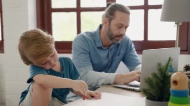 Baba işte oturup tablet kullanırken oğul resim çiziyor, aile ilişkileri kavramı.