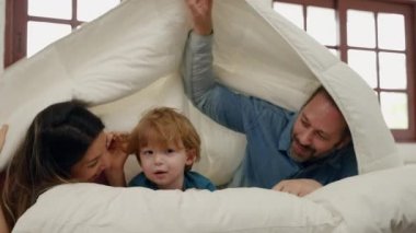 Anne ve babanın yatakta oğlanla alay etmesi, aile ilişkisi kavramı.