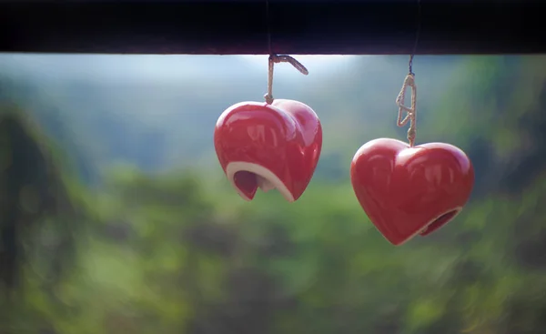 バレンタインデー 結婚式に使用される選択的フォーカスバレーの木製のビームにかかっている赤いセラミックの心のペア — ストック写真