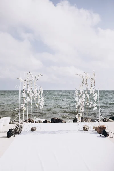 海岸上的白色兰花婚礼拱门 — 图库照片