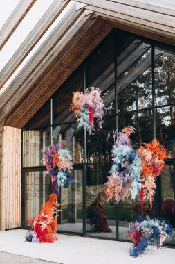 Düğün alanı dekoratif paneller ve renkli çiçek düzenlemeleri ile dekore edilmiştir.