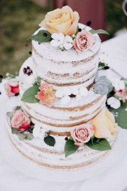 Çiçekli ve süslemeli düğün pastası.