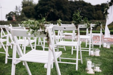 Sandalyeler ve çiçeklerle güzel bir düğün töreni.