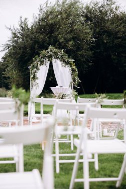 Sandalyeler ve çiçeklerle güzel bir düğün töreni.