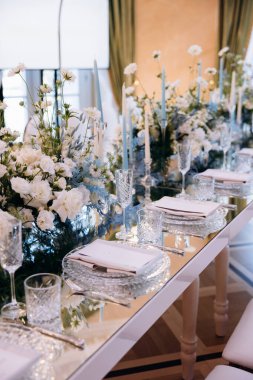 Farklı çiçekler ve bardaklarla dolu güzel bir masa.