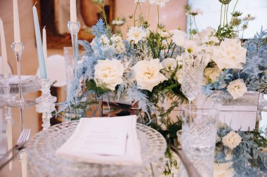 Farklı çiçekler ve bardaklarla dolu güzel bir masa.