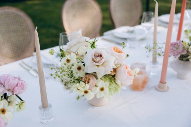 Çiçekler ve mumlarla düğün masası.